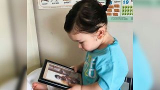 Taimur Ali Khan Lovingly Looks At Papa Saif Ali Khan's Picture As He Sports A Ponytail Taimur Ali Khan Lovingly Looks At Papa Saif Ali Khan's Picture As He Sports A Ponytail