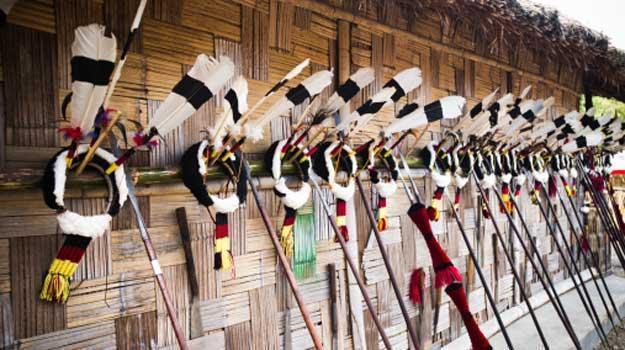 Feather headdresses with spears on the wall of a tribal hut in Kohima, Nagaland