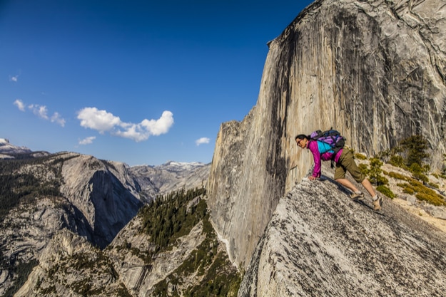 Climber peers over the edge of an abyss in Yosemite National Park
