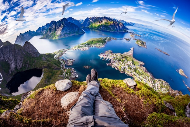 First person perspective shot from a hiker sitting at the edge of a cliff at Lofoten is an archipelago in the county of Nordland, Norway