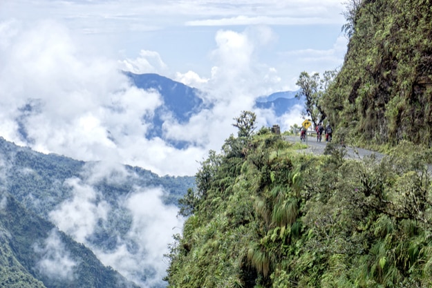Mountain bikers riding the famous downhill trail Road of death in Bolivia