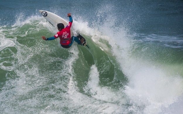 Surfer rides a wave in Punta Hermosa beach, Peru