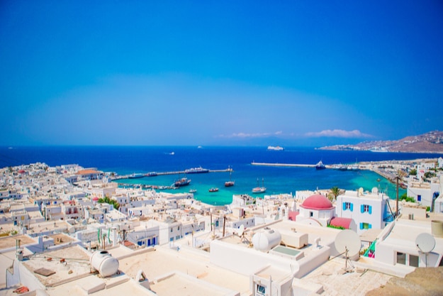 Top view of the old city and the sea on the island of Mykonos, Greece. A lot of white houses against the blue sky