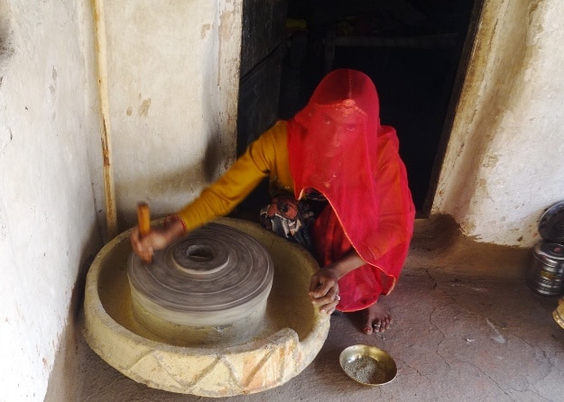 A woman in Bishnoi village operates the stone mill