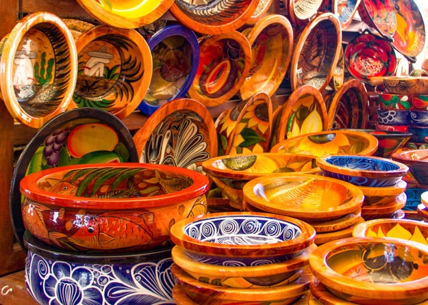 Mexican pottery in bold earthy colors and patterns. At artisan market in Puerto Vallarta, Mexico.