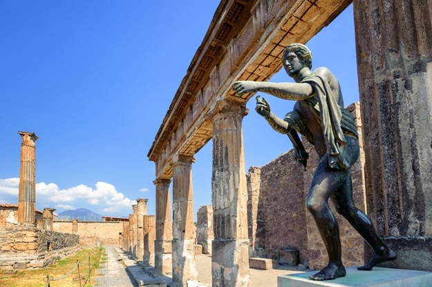 Ruins of the antique Temple of Apollo with bronze Apollo statue in Pompeii, Naples, Italy. Pompeii was destroyed by Vesuvius eruption in 79 AD