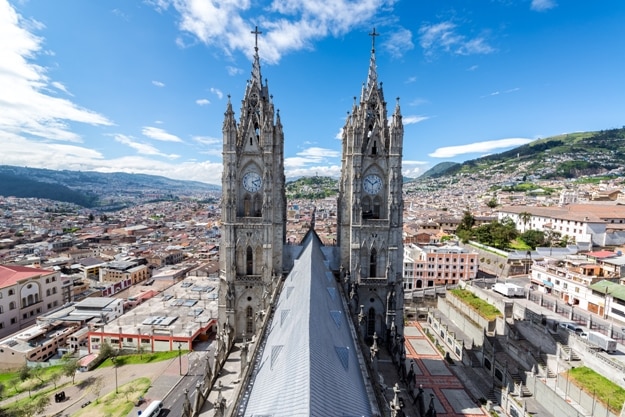 View of the towers of the Basilica in Quito, Ecuador with the city visible in the background