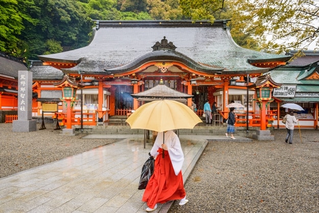 A shinto priest and tourists at Kumano Nachi Taisha Shrine's Heiden hall. The Temple is a World Heritage Site