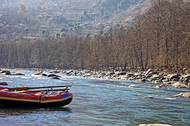 Anchored white water rafting boat in the Himalayas at the Beas river in Manali, India