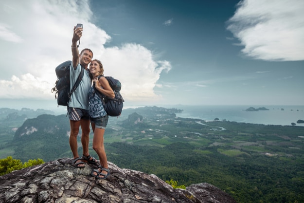 Two hikers taking selfie on top of the mountain
