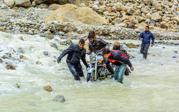 Bikers helping each other through water crossing
